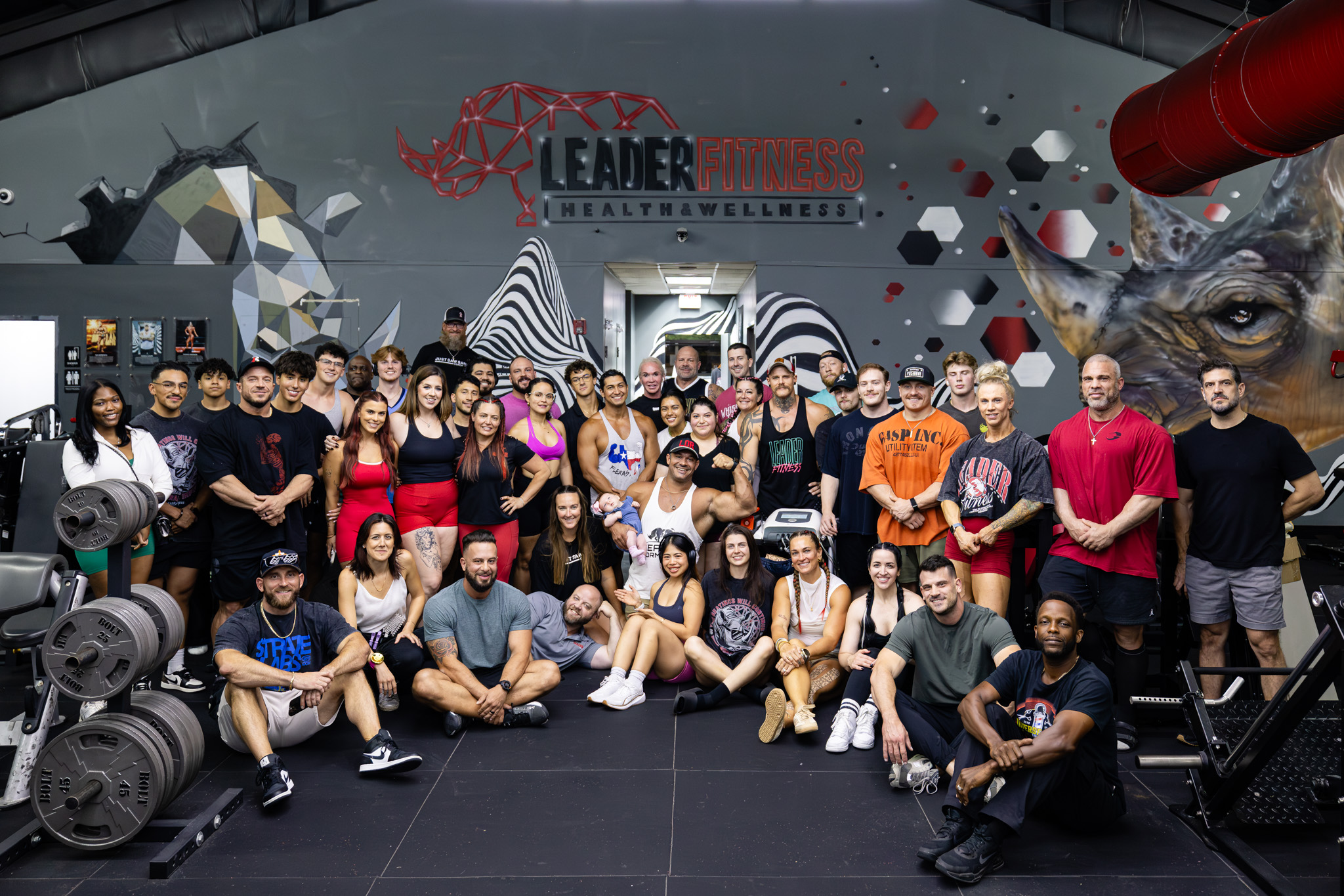 The Leader Fitness member community gathered in front of the gym's rhino mural
