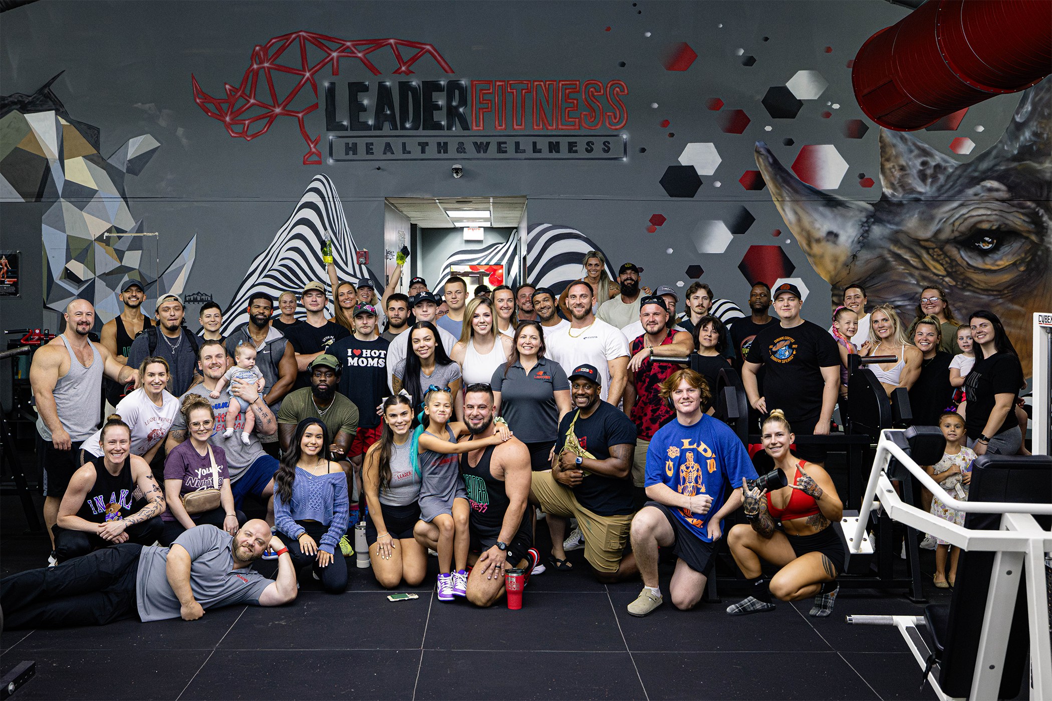 The Leader Fitness member community gathered in front of the gym's rhino mural